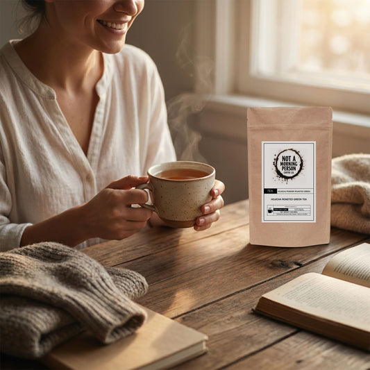 woman who is happy to be drinking a cup of not a morning person coffee co hojicha roasted green tea powdered tea.